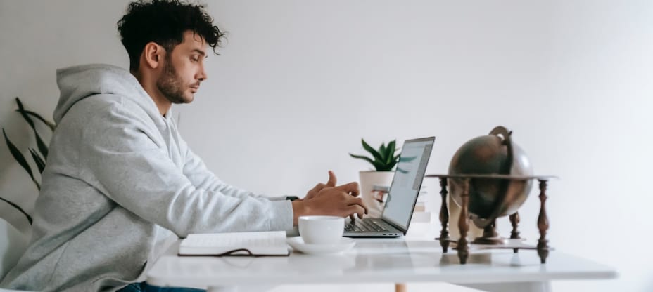 A man sitting at a laptop, browsing