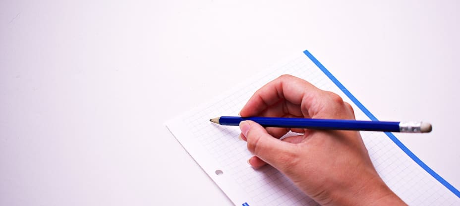 a hand holding a pencil over a sheet of paper