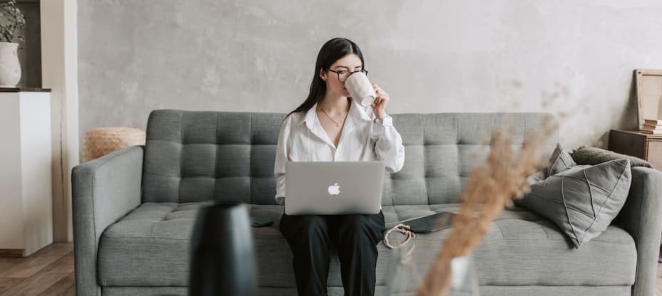 a woman sitting on a couch with a laptop