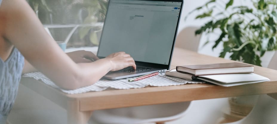 a woman sitting by a desk with a computer on it