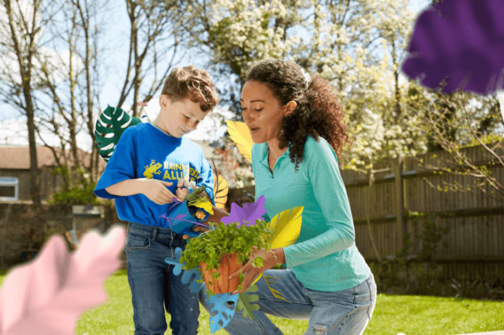 the mother and her son watering plants in a sunny garden