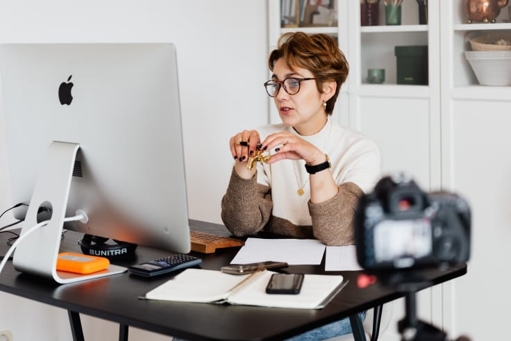 woman sits in front of computer and explains knowledge management process
