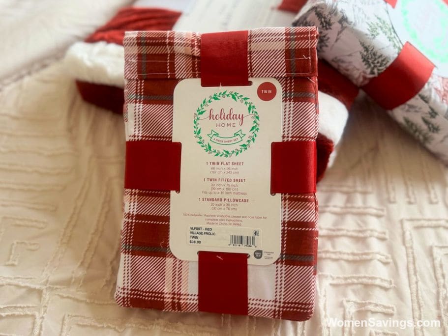 Festive holiday comforter set and sheet set displayed on a bed from the Macy's holiday bedding sale