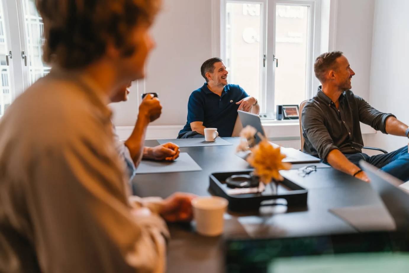 Colburn team members sharing ideas around a meeting table in the Malmö office