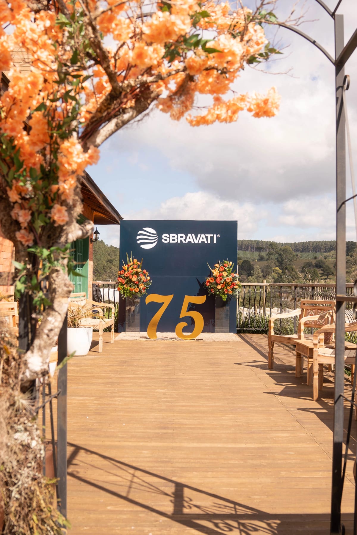 Deck da Casa França decorado para o evento de 75 anos, com vista para a serra