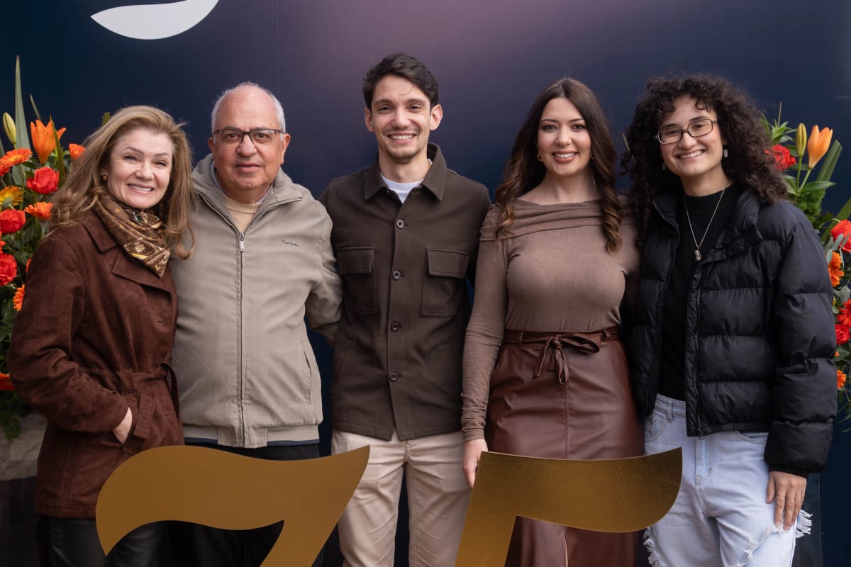 Grupo de convidados posando juntos no evento de 75 anos