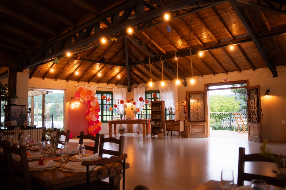 Salão da Casa França com luzes de festa e vista para o deck