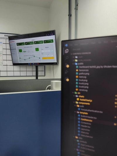 Painel com dashboard de produção ao lado de editor de código