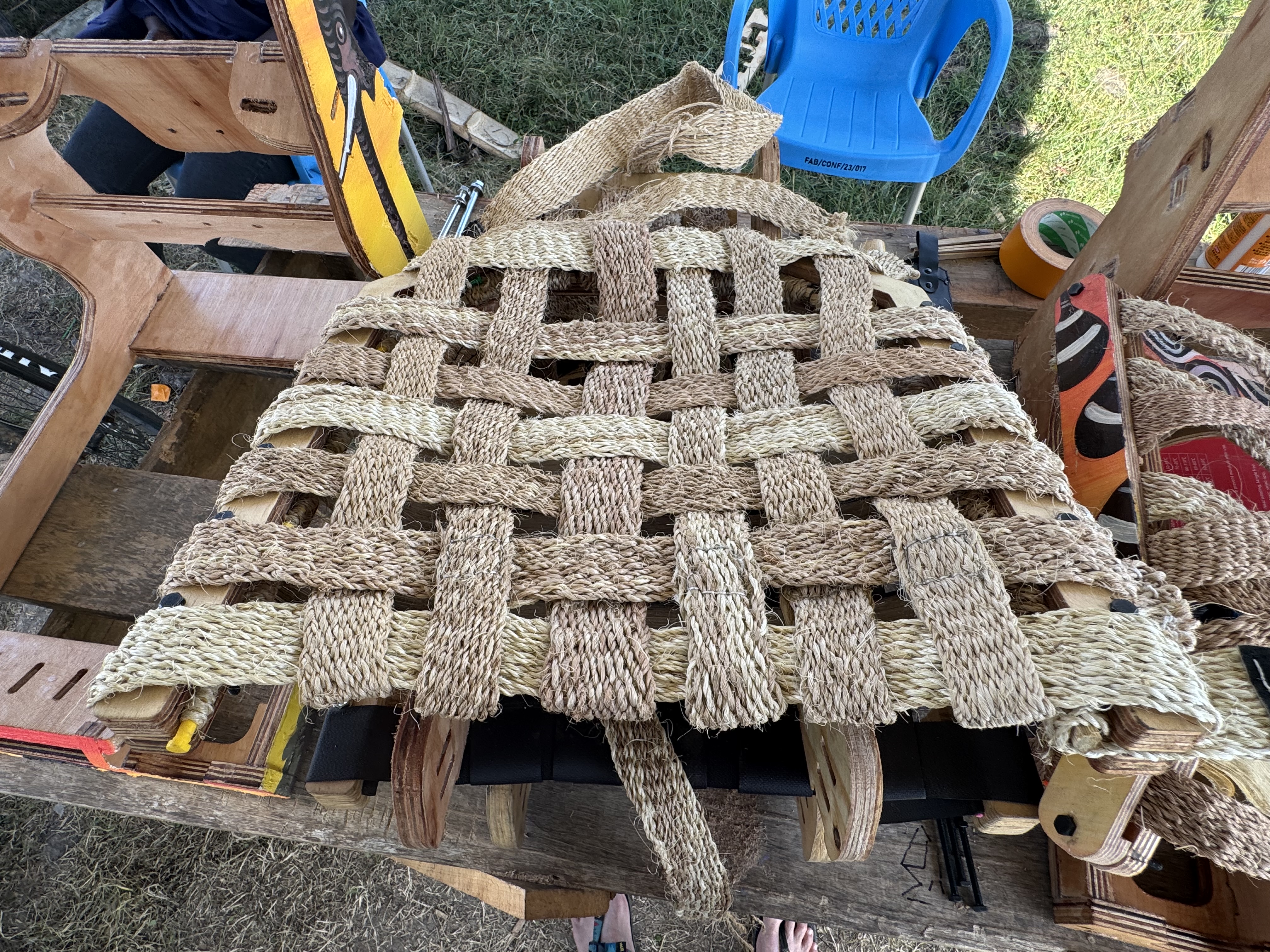 Craftsperson weaving the seat surface by hand at FabLab Winam