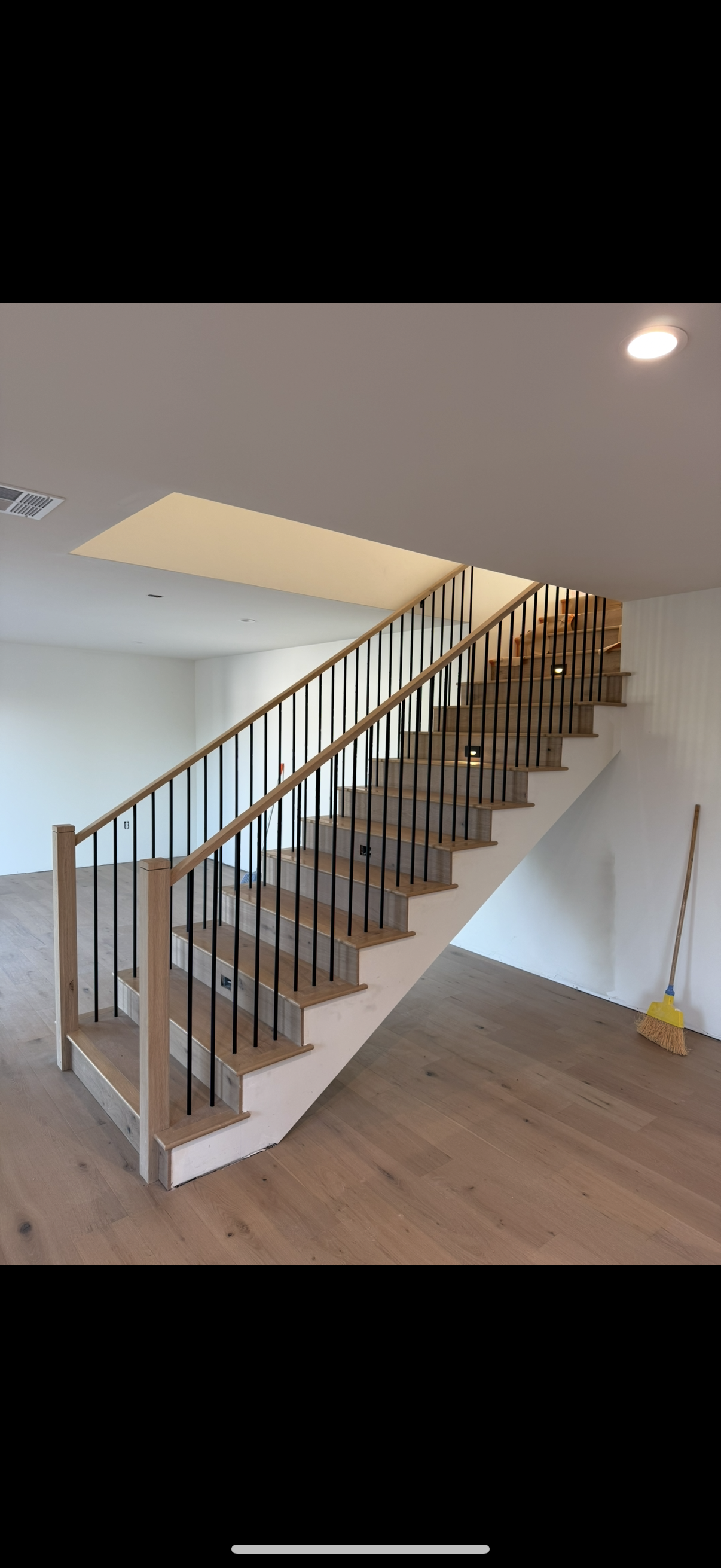 Oak handrail with white painted risers and black square balusters