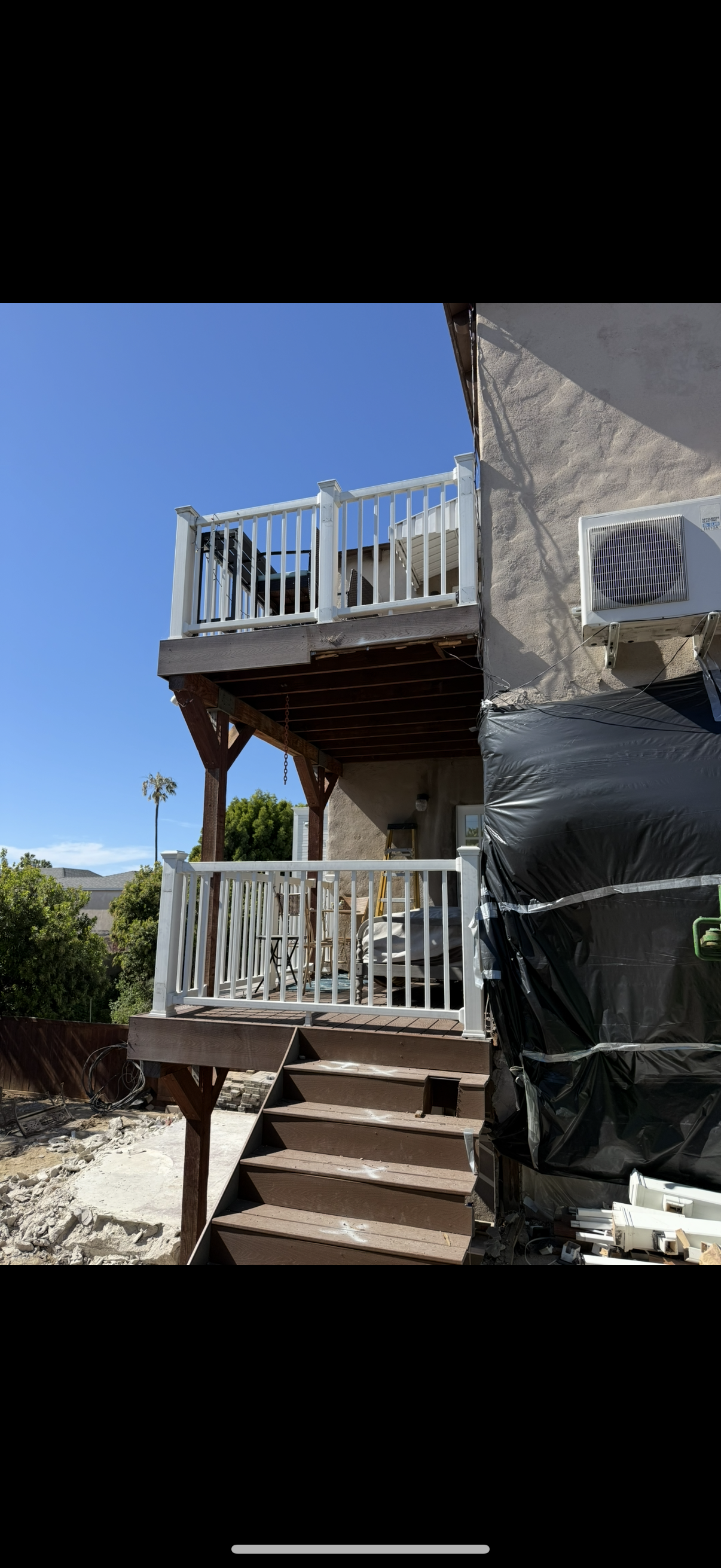 Two-story deck with staircase and white railing