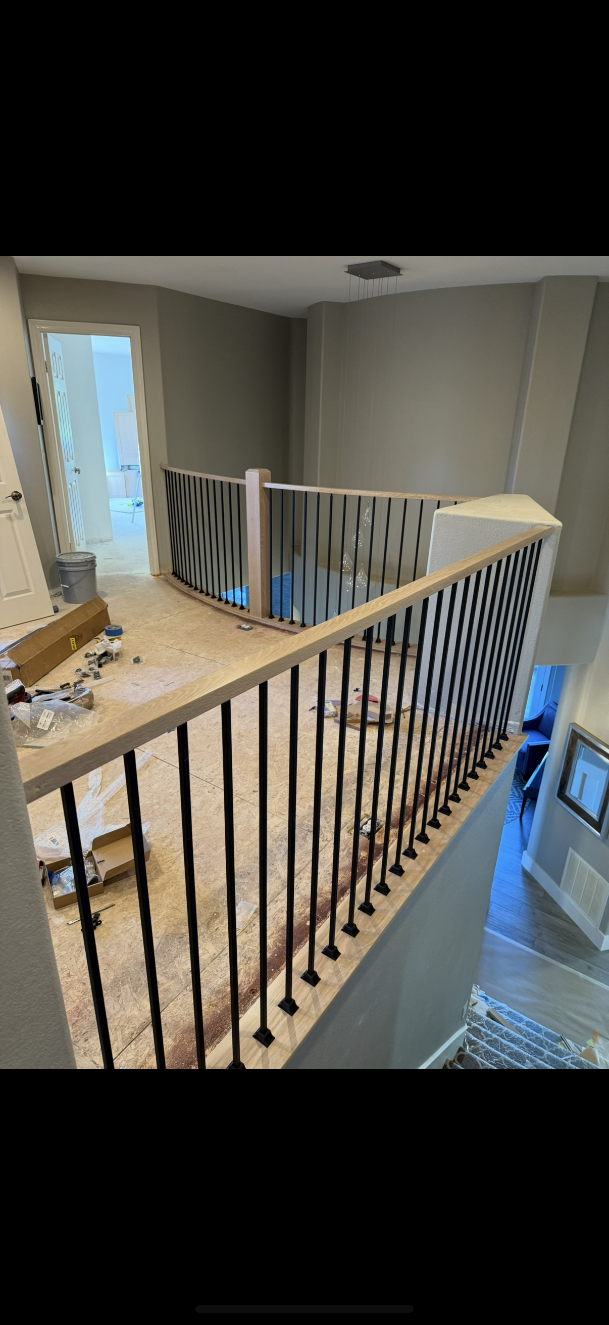 Oak handrail with black square metal balusters on interior staircase