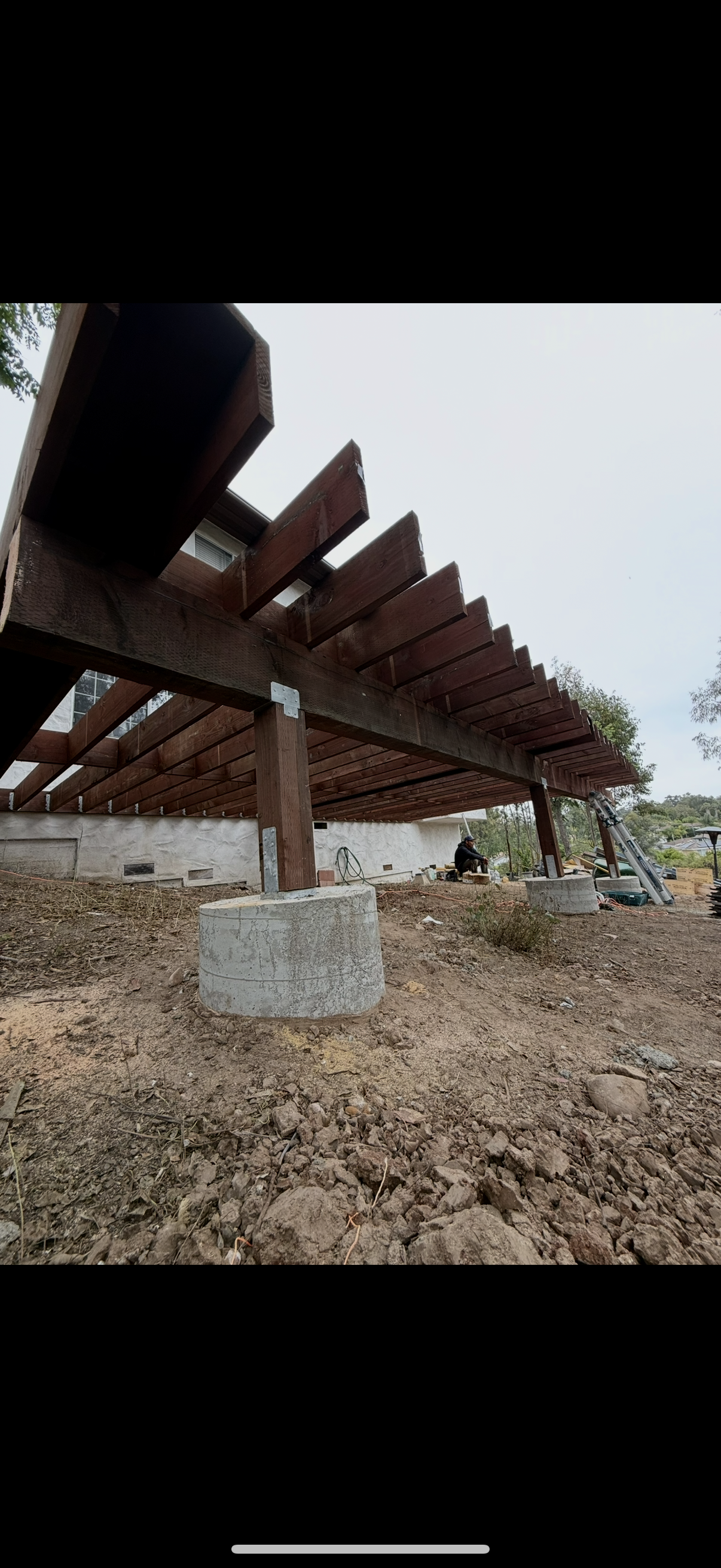 Heavy timber pergola structure with concrete pier footings