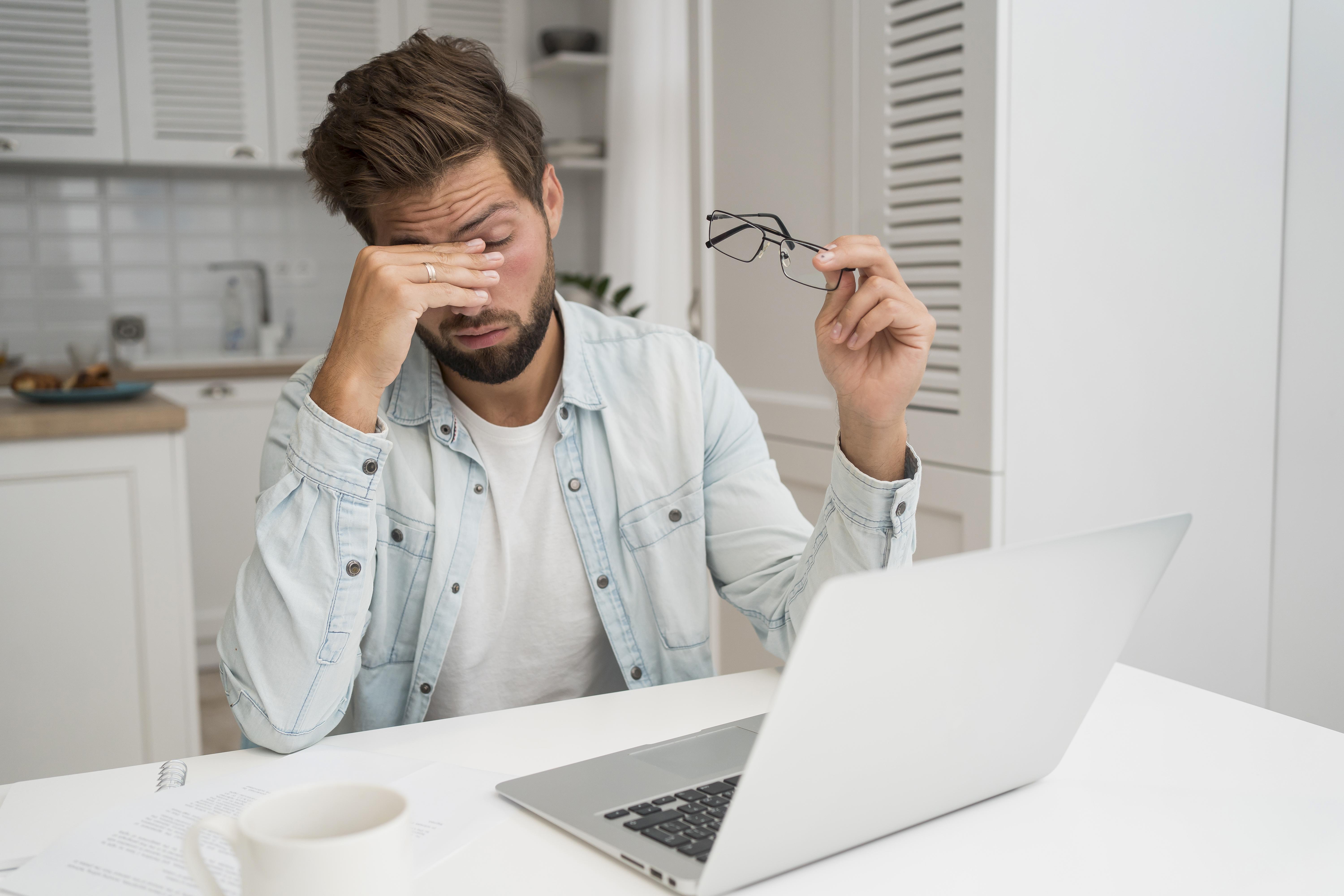 Person experiencing digital eye strain while working on computer
