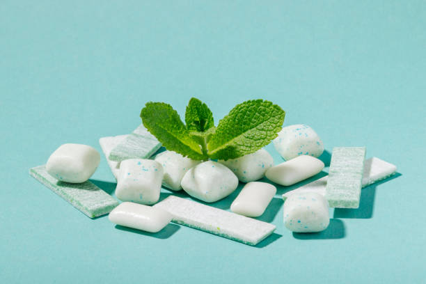 A bunch of mint chewing gum and fresh mint leaves