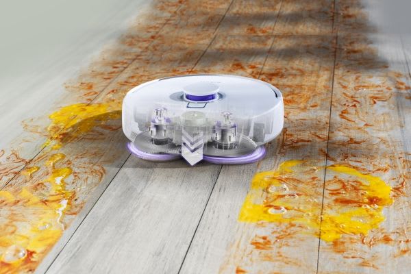 A robotic vacuum cleaner navigates a floor, demonstrating the efficiency of vacuum mops vs steam mops for cleaning.