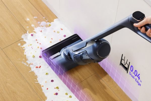 A person using a vacuum cleaner on a floor with spilled liquid, illustrating how to clean vacuum brush roll effectively.