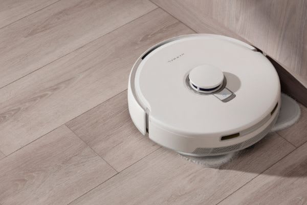 自動掃除機が床をクリーンにする風景。家事の自動化が進んでいる現代の便利なアイテム。