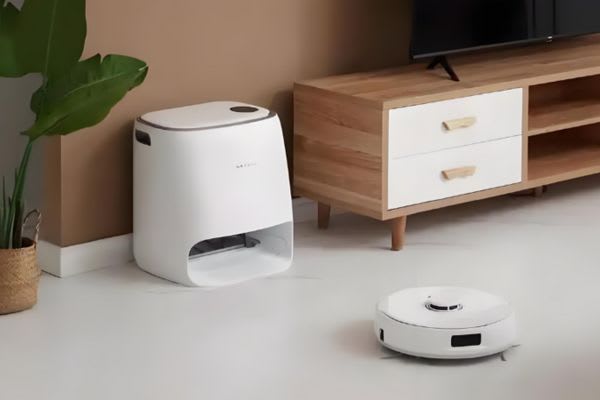 部屋に置かれたロボット掃除機とゴミ捨て用のコンテナがある、便利な暮らしを感じる一場面。