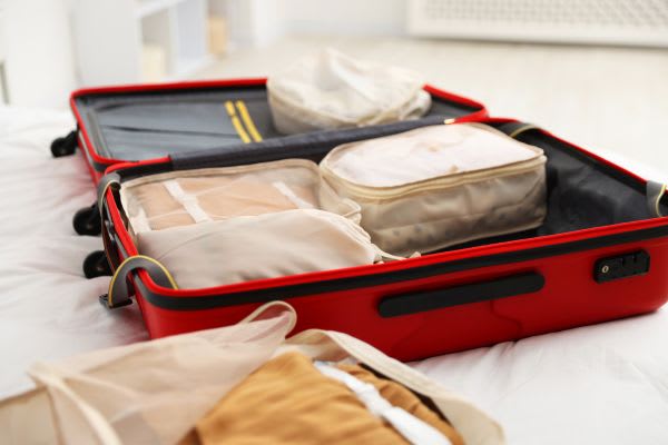 赤いスーツケースの中に整理された荷物があり、旅行の準備を感じさせる。シルバーウィークに向けて。