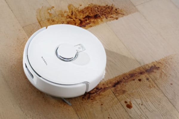 床の上にあるロボット掃除機が、家事とは言えない家事をこなしています。汚れをきれいに掃除中です。