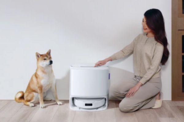 女性が掃除機の前で犬と一緒に座り、掃除ができる人の特徴を見せています。