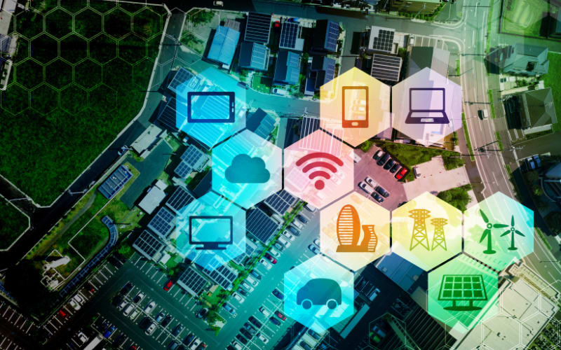 Aerial view of urban area with solar panels and icons representing technology trends influencing the barcode scanner market.