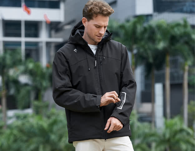 A man in a black jacket compares parka vs puffer styles, looking stylish against a modern backdrop.