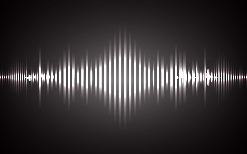 Visual representation of sound waves illustrating scanner sound in a dark background, showcasing rhythmic peaks and troughs.