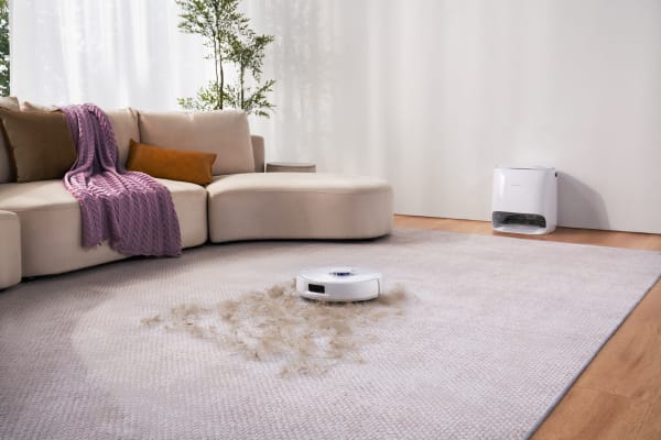 A robotic vacuum cleaner on a carpet, showcasing dirt and debris, raises questions about what is a good suction power for vacuum cleaner.