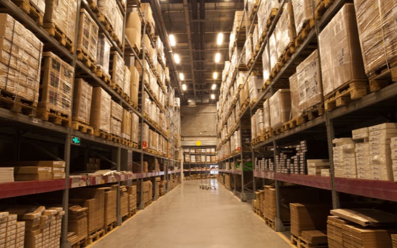 A well-organized warehouse with high shelves, showcasing products ready for scanning with a pistol grip scanner.