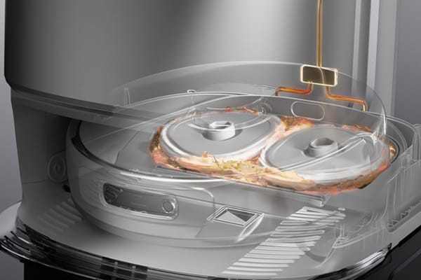 A close-up view of a robot vacuum with docking station displaying its cleaning mechanism and components.