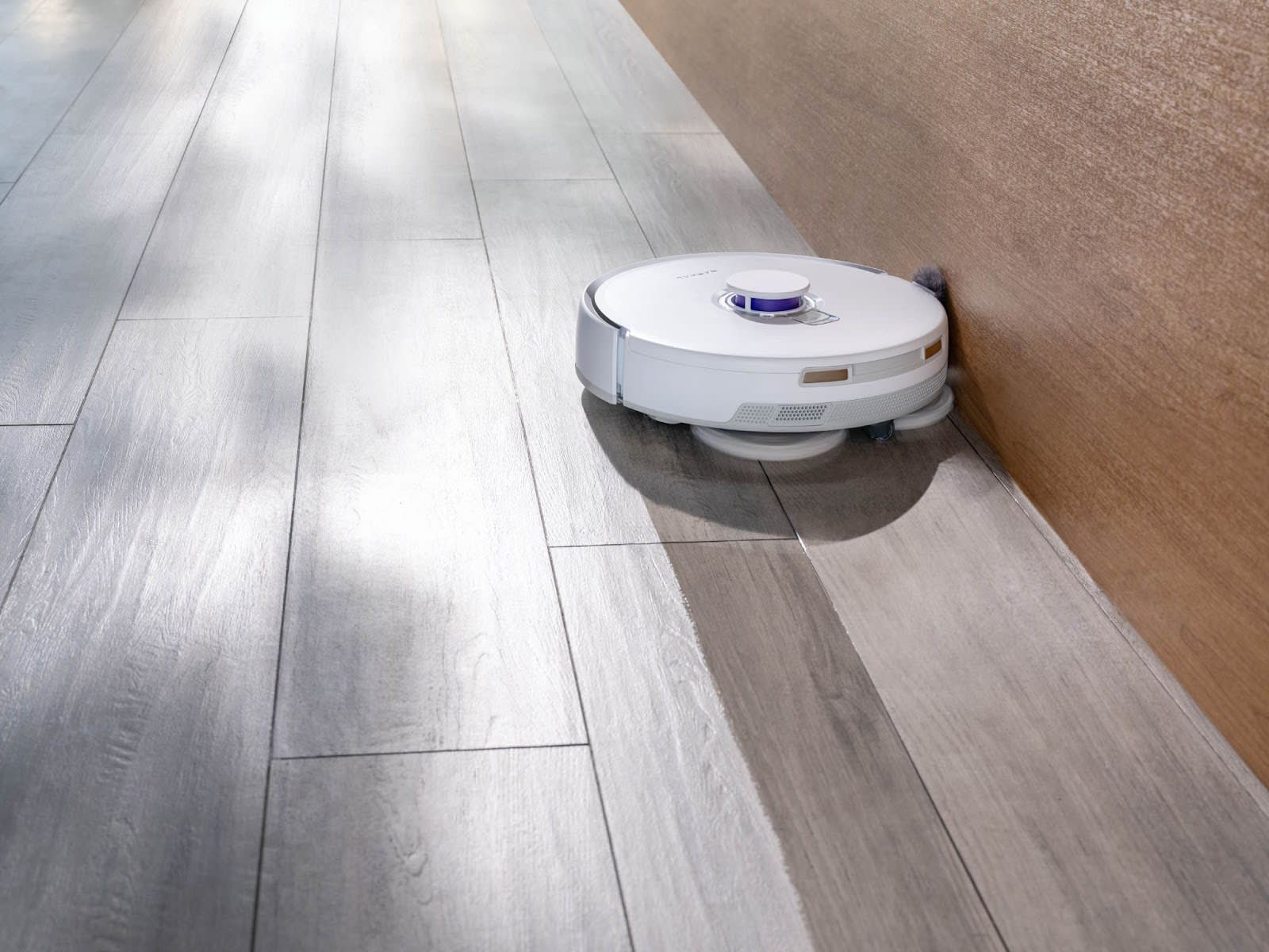 A robotic vacuum navigating between different textures, showcasing excellent flooring compatibility.