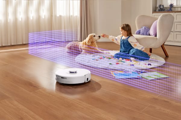 A robot vacuum approaches a child and a dog on a rug, showcasing how can robot vacuums go over rugs.