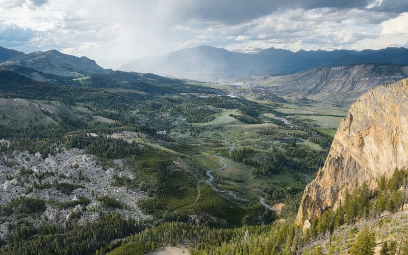 A breathtaking aerial view of lush valleys and rugged mountains, perfect for Yellowstone hikes.