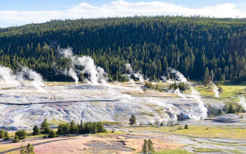 A stunning view of steam rising from geothermal features, perfect for exploring Yellowstone hikes.
