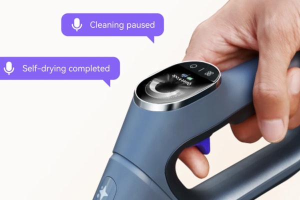 A hand holding a vacuum cleaner with voice prompts showing how to use vacuum cleaner features.