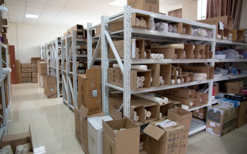 Storage area filled with boxes and shelves, essential for testing and adhering to drop test standards.