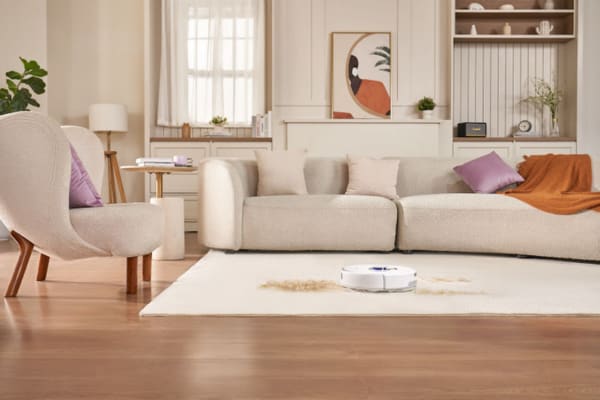 A modern living room with a robot vacuum cleaning carpet, showcasing tips for Robot Vacuums: How to Get the Best Performance on Carpets.