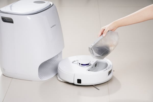 A hand is removing the dustbin from a robot vacuum, illustrating how to use a robot vacuum for quick clean-ups.