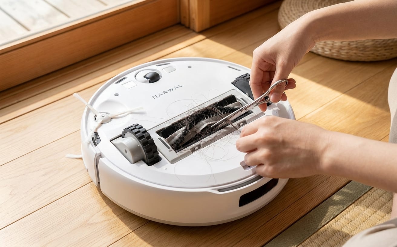 ロボット掃除機のお手入れ中、髪の毛を取り除くためにハサミを使っている手元が写っています。