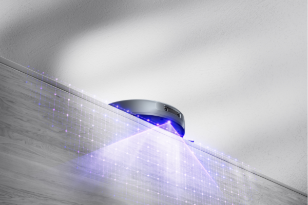 A robot vacuum navigating a ledge, illustrating how to troubleshoot your robot vacuum’s navigation issues effectively.