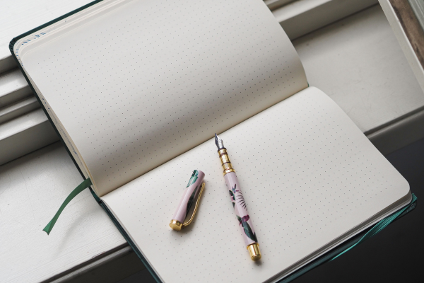 An open notebook with a decorative pen, perfect for jotting down ideas during your spring clean up.