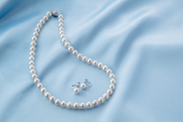 Elegant pearl necklace and earrings displayed on soft fabric, perfect for memorable Valentine's Day gifts.