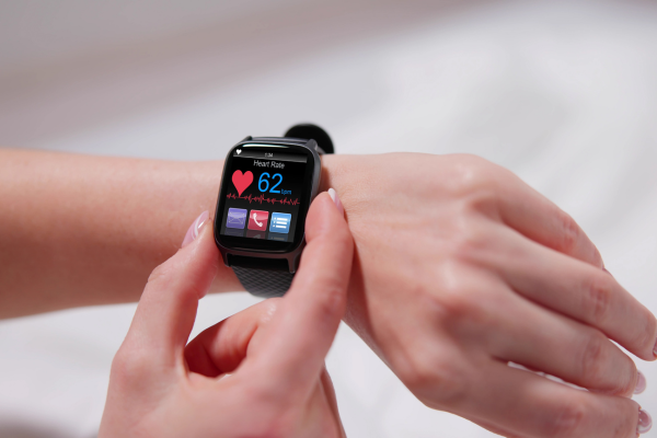 A close-up of a woman's hand checking her smartwatch, perfect for tracking health with thoughtful Mother's Day gifts.