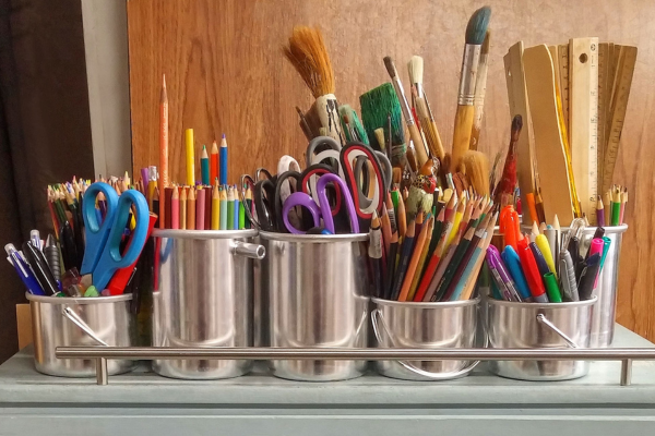 A colorful collection of art supplies in metal containers, ideal for creative mother's day gifts to inspire creativity.