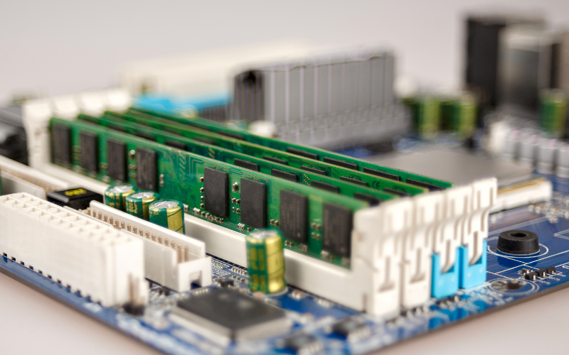 A close-up of a motherboard featuring RAM modules and components essential for connecting storage devices.