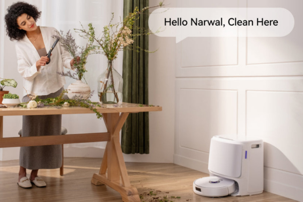 A person interacts with a smart robot vacuum, showcasing The Future of Robot Vacuum Technology in a modern home setting.