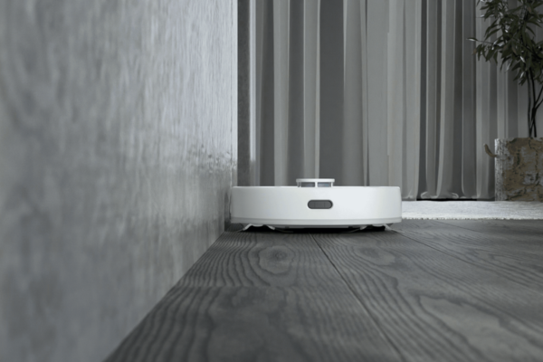 A sleek robot vacuum efficiently cleaning near a wall, showcasing the best robot vacuum for cleaning corners and edges.