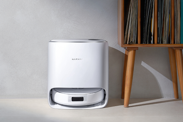 A sleek white robot vacuum sits on a concrete floor, showcasing the best vacuum for concrete floors in a modern setting.